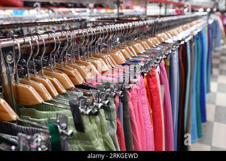 Damenhosen hängen in einem Laden hintereinander Stockfoto