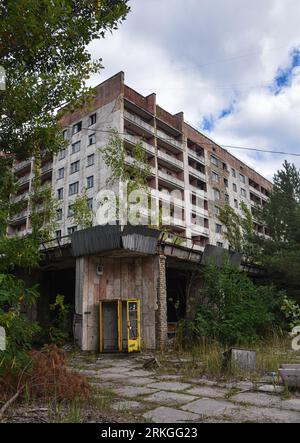 An old abandoned hotel situated in a tranquil wooded area near another building in Chernobyl Stock Photo
