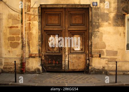 An aged structure features a grand wooden entrance door, creating a classic and timeless aesthetic Stock Photo