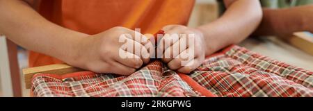 Teilansicht eines Knopftuchs in der Nähe eines Freundes während des Unterrichts in der montessori-Schule, Banner Stockfoto