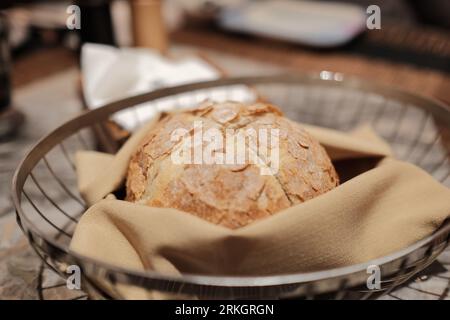 An artfully arranged basket containing freshly baked bread on a cloth napkin Stock Photo