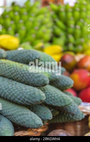 A selection of fresh green vegetables including cucumbers, displayed in a natural wicker basket Stockfoto