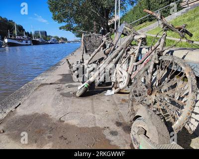 Bikes, e-scooters and shopping carts salvaged from waterway. Aura river, Turku, Finland. Stock Photo