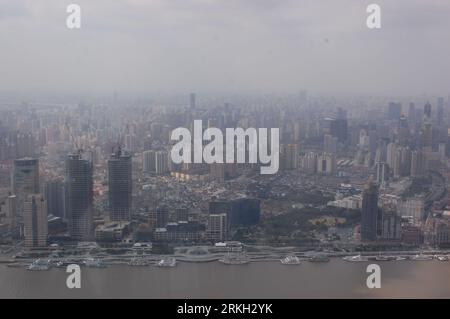 An aerial view of a bustling cityscape of Shanghai with a busy harbor covered in smog Stock Photo