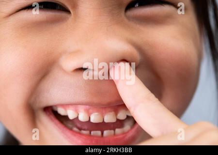 Ein Foto von einem süßen Mädchen im Vorschulalter, das ein lustiges, dummes Gesicht macht. Stockfoto