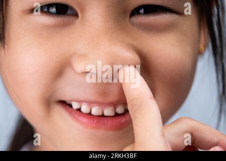 Ein Foto von einem süßen Mädchen im Vorschulalter, das ein lustiges, dummes Gesicht macht. Stockfoto