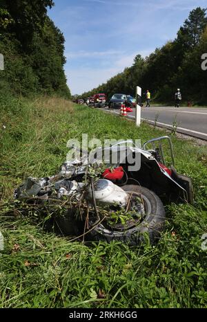 Schongau, Deutschland. 25. August 2023. Beschädigte Motorroller liegen an der Bundesstraße 17 um ein zerstörtes Auto herum. Nach Angaben der Polizei wurden bei einem Unfall mit zwei Autos und einer Gruppe von Motorrädern in Oberbayern mehrere Personen, einige davon schwer verletzt. Quelle: Karl-Josef Hildenbrand/dpa/Alamy Live News Stockfoto