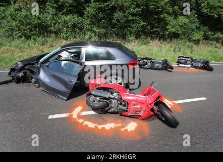 Schongau, Deutschland. 25. August 2023. Beschädigte Motorroller liegen an der Bundesstraße 17 um ein zerstörtes Auto herum. Nach Angaben der Polizei wurden bei einem Unfall mit zwei Autos und einer Gruppe von Motorrädern in Oberbayern mehrere Personen, einige davon schwer verletzt. Quelle: Karl-Josef Hildenbrand/dpa/Alamy Live News Stockfoto