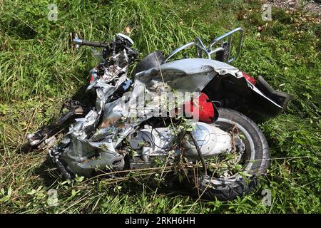 Schongau, Germany. 25th Aug, 2023. A destroyed motor scooter lies in the grass next to the Bundesstraße 17. According to the police, several people were injured, some of them seriously, in an accident involving two cars and a motorcycle group in Upper Bavaria. Credit: Karl-Josef Hildenbrand/dpa/Alamy Live News Stock Photo