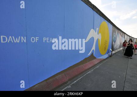 Bildnummer: 55689688  Datum: 06.08.2011  Copyright: imago/Xinhua (110810) -- BERLIN, August 10, 2011 (Xinhua) -- Tourists walk along East Side Gallery, the largest remaining part of the former Berlin Wall in Berlin, capital of Germany on August 6, 2011. Berlin is marking the 50th anniversary of the Berlin Wall, which started building on August 13, 1961. (Xinhua/Ma Ning) GERMANY-BERLIN WALL-50 ANNIVERSARY PUBLICATIONxNOTxINxCHN Gesellschaft Politik Fotostory Berliner Mauer Mauerbau DDR Deutsche Teilung xdp 2011 quer o0 malerei, Kunst, Kultur    Bildnummer 55689688 Date 06 08 2011 Copyright Imag Stock Photo