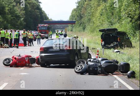 Schongau, Germany. 25th Aug, 2023. Damaged scooters lie on the Bundesstraße 17 around a destroyed car. According to the police, several people were injured, some of them seriously, in an accident involving two cars and a group of motorcycles in Upper Bavaria. Credit: Karl-Josef Hildenbrand/dpa - ATTENTION: License plate(s) have been pixelated for legal reasons/dpa/Alamy Live News Stock Photo