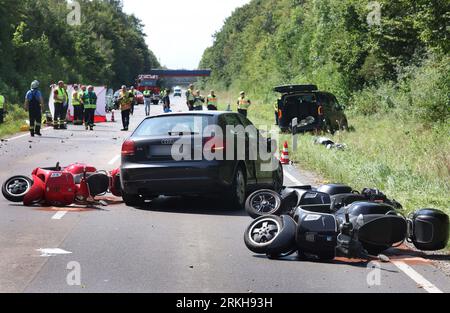 Schongau, Germany. 25th Aug, 2023. Damaged scooters lie on the Bundesstraße 17 around a destroyed car. According to the police, several people were injured, some of them seriously, in an accident involving two cars and a group of motorcycles in Upper Bavaria. Credit: Karl-Josef Hildenbrand/dpa - ATTENTION: License plate(s) have been pixelated for legal reasons/dpa/Alamy Live News Stock Photo