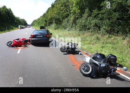 Schongau, Germany. 25th Aug, 2023. Damaged scooters lie on the Bundesstraße 17 around a destroyed car. According to the police, several people were injured, some of them seriously, in an accident involving two cars and a group of motorcycles in Upper Bavaria. Credit: Karl-Josef Hildenbrand/dpa - ATTENTION: License plate(s) have been pixelated for legal reasons/dpa/Alamy Live News Stock Photo