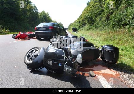 Schongau, Germany. 25th Aug, 2023. Damaged scooters lie on the Bundesstraße 17 around a destroyed car. According to the police, several people were injured, some of them seriously, in an accident involving two cars and a group of motorcycles in Upper Bavaria. Credit: Karl-Josef Hildenbrand/dpa - ATTENTION: License plate(s) have been pixelated for legal reasons/dpa/Alamy Live News Stock Photo