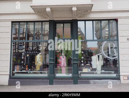 A tailor's shop window, with a reflection of half-timbered houses in the glass Stock Photo