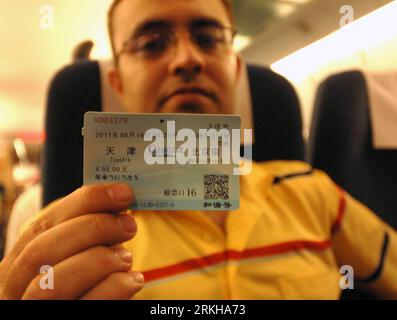 Bildnummer: 55774777  Datum: 16.08.2011  Copyright: imago/Xinhua (110816) -- TIANJIN, Aug. 16, 2011 (Xinhua) -- A foreign tourist shows his price-cut train ticket in a Beijing-Tianjin Highspeed Train in Tianjin City, north China, Aug. 16, 2011. The highest speed of the Highspeed Train between Beijing, capital of China, and neighboring Tianjin was downward adjusted to 300 kilometers per hour from the previous 350 kilometers per hour from Tuesday. After the adjustment, the intercity train will run 33 minutes, three minutes more than before. The first and second class seat prices have been cut by Stock Photo