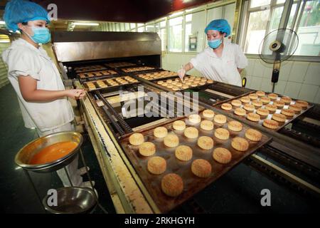 Bildnummer: 55832290 Datum: 25.08.2011 Copyright: imago/Xinhua (110826) -- PEKING, 26. August 2011 (Xinhua) -- Arbeiter bürsten Mondkuchen mit Ei vor dem Backen in einer Werkstatt von Daoxiangcun, einem altehrwürdigen Lebensmittelunternehmen, in Peking, China, 25. August 2011. Die Arbeiter von Daoxiaocun sind mit der Herstellung verschiedener Arten von Mondkuchen beschäftigt, um die große Nachfrage zu befriedigen, da das traditionelle chinesische Mid-Herbstfest naht. Das diesjährige Mid-Autumn Festival findet am 12. September statt. (Xinhua/Chen Xiaogen) (hdt) #CHINA-BEIJING-MOON CAKE-DAOXIANGCUN (CN) PUBLICATIONxNOTxINxCHN Wirtschaft Mondkuchen Kuchen Produktion backen Stockfoto