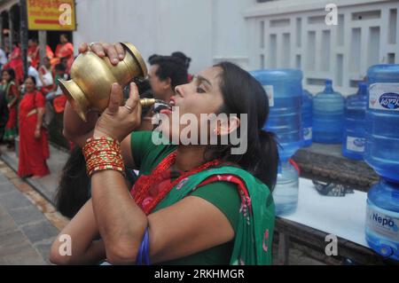 Bildnummer: 55868380  Datum: 31.08.2011  Copyright: imago/Xinhua (110831) -- KATHMANDU, Aug. 31, 2011 (Xinhua) -- A Nepalese Hindu woman drinks water at Pashupati Nath Temple during the celebration of the Teej festival in Kathmandu, capital of Nepal, on Aug. 31, 2011. Married Hindu women wearing red bridal dresses celebrate the Teej festival by praying for a long life and the well-being of their husbands. Unmarried women observe the festival by praying for a good husband. (Xinhua/Niraj Sapkota) (zwx) NEPAL-KATHMANDU-TEEJ FESTIVAL PUBLICATIONxNOTxINxCHN Gesellschaft Religion Hinduismus Traditio Stock Photo