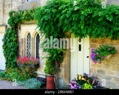 Haus bedeckt mit einem Kriechgang mit Sommerblumen draußen im Ripley North Yorkshire England Stockfoto