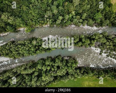 Aerial view of a winding river snaking through a lush forest in Switzerland Stock Photo