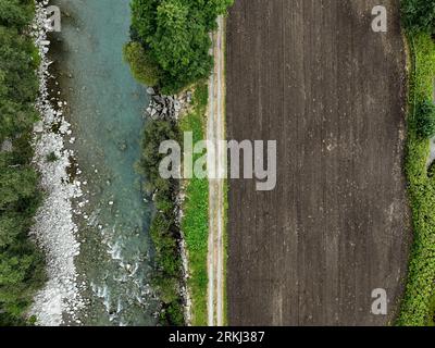 Aerial view of a winding river snaking through a lush forest in Switzerland Stock Photo