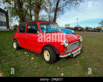 Old red 1963 Austin Mini Cooper S Mark I sedan on the lawn. Classic car show. Sunny day. Stock Photo