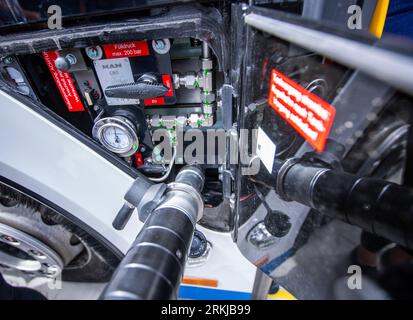 Rostock, Deutschland. 02. Aug. 2023. Der Tankschlauch zum Betanken mit Biomethan steckt im Tankschacht eines Stadtbusses im neuen Depot der Rostocker Straßenbahn AG (RSAG) fest. Nach sechs Monaten Umbauarbeiten wurde der Standort für Linienbusse an alternative Antriebssysteme angepasst. Die Busse können mit elektrischer Energie und Biomethan betankt werden, und es ist geplant, alle Busdienste in den nächsten Jahren schrittweise auf klimafreundliche Antriebssysteme umzustellen. Kredit: Jens Büttner/dpa/Alamy Live News Stockfoto