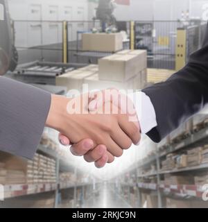 Geschäftsleute, die abstrakte Logistik- und Lagerkonzepte in die Hand nehmen. Handelsvereinbarung. Teamarbeit und Partnerschaft. Stockfoto