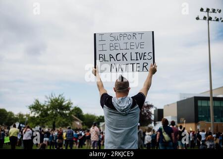 Ein Mann, der während der Proteste von Black Lives Matter ein Banner hält Stockfoto