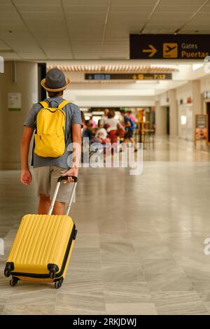 Unbekannter Mann mit Koffer am Flughafen Stockfoto