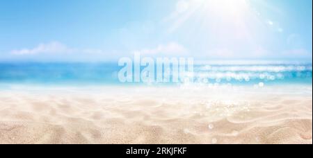 Sand Mit Blauem Meer - Strand Sommer Unschärfe Hintergrund Mit Glitzernden Sonnenlichtern Stockfoto
