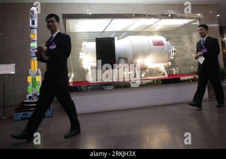 Bildnummer: 56136837  Datum: 29.09.2011  Copyright: imago/Xinhua (110929) -- BEIJING, Sept. 29, 2011 (Xinhua) -- Staff members walk past models of Tiangong-1 space lab module (C) and an ameliorated Long-March 2FT1 carrier rocket at Beijing Aerospace Control Center in Beijing, capital of China, Sept. 29, 2011. Commander-in-chief of China s manned space program Chang Wanquan announced Thursday night that the launch of Tiangong-1 space lab module was successful. (Xinhua/Wang Shen) (hdt) (TIANGONG-1)CHINA-SPACE LAB MODULE-LAUNCH-SUCCESS (CN) PUBLICATIONxNOTxINxCHN Gesellschaft Raumfahrt Kontrollze Stock Photo