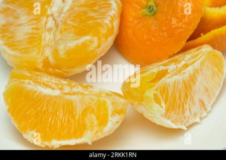 Vorbereitete Orange verzehrfertig mit Segmenten neben der Haut Stockfoto