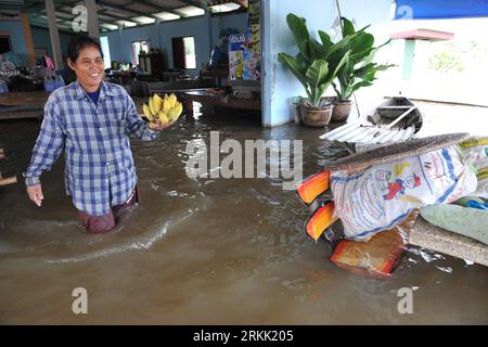 Bildnummer: 56185863  Datum: 16.10.2011  Copyright: imago/Xinhua (111016) -- BANGKOK, Oct. 16, 2011 (Xinhua) -- A woman walks through flood water in Tha-sung district, Uthai Thani Province, central Thailand, Oct. 16, 2011. Thai Agriculture Minister Theera Wongsamut assured on Sunday that Bangkok would be safe from flooding formerly expected on weekend as northern runoff from upstream has already passed Bangkok and drifted into sea. (Xinhua/Rachen Sageamsak) (zf) THAILAND-DISASTER-FLOOD PUBLICATIONxNOTxINxCHN Gesellschaft Hochwasser Thailand x0x xtm 2011 quer      56185863 Date 16 10 2011 Copyr Stock Photo