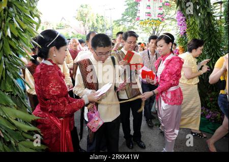 Bildnummer: 56195783  Datum: 19.10.2011  Copyright: imago/Xinhua (111019) -- PATTAYA, Oct. 19, 2011 (Xinhua) -- Bridegrooms give away red packets in order to see their brides according to the traditional Thai marriage custom in Pattaya, Chon Buri, Tailand, Oct. 19, 2011. Altogether 60 couples from China take part in a traditional Thai wedding ceremony here on Wednesday. (Xinhua/Song Zhenping) (zys) TAILAND-PATTAYA-CHINESE-GROUP WEDDING CEREMONY PUBLICATIONxNOTxINxCHN Gesellschaft Tradition Land Leute Hochzeit Hochzeitsprozession Prozession xbs x0x 2011 quer      56195783 Date 19 10 2011 Copyri Stock Photo