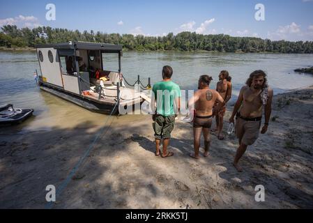 Batina, Kroatien. August 2023. Die Bürger von Liberland bringen am 24. August Lebensmittel und Ausrüstung auf dem Schiff Swan in Liberland in der Nähe von Batina, Kroatien, mit. 2023. Liberland, auch als Freie Republik Liberland bekannt, ist eine unerkannte Mikronation in Südosteuropa, die unbewohnte Parzelle umstrittenen Landes am Westufer der Donau zwischen Kroatien und Serbien beansprucht. Es wurde am 13. April 2015 von einem euroskeptischen Politiker aus der Tschechischen Republik, Vit Jedlicka, proklamiert. Foto: Davor Javorovic/PIXSELL Credit: Pixsell/Alamy Live News Stockfoto