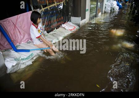 Bildnummer: 56227862  Datum: 29.10.2011  Copyright: imago/Xinhua (111029) -- BANGKOK, Oct. 29, 2011 (Xinhua) -- A girl sits on the sandbags in Bangkok, capital of Thailand, Oct. 29, 2011. in Bangkok are bracing for the flood disaster, which has been ravaging the country for more than three months and shows no sign of receding. (Xinhua/Lui Siu Wai) THAILAND-BANGKOK-FLOOD PUBLICATIONxNOTxINxCHN Gesellschaft Thailand Hochwasser x0x xtm premiumd 2011 quer Highlight      56227862 Date 29 10 2011 Copyright Imago XINHUA  Bangkok OCT 29 2011 XINHUA a Girl sits ON The sandbags in Bangkok Capital of Tha Stock Photo