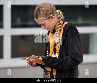 A young fan reading the program during the Sky Bet Championship match Hull City vs Bristol City at MKM Stadium, Hull, United Kingdom, 25th August 2023  (Photo by Mark Cosgrove/News Images) Stock Photo