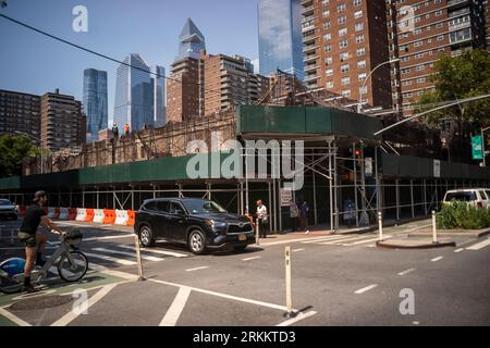 Vacant commercial building being demolished covered with scaffolding and a sidewalk shed, formerly housing a McDonald’s, a Gristedes supermarket, a tennis center and some small businesses, in Chelsea in New York on Wednesday, August 9, 2023. The building, owned by the cooperative Mutual Redevelopment Housing, has reached the end of its lifespan and is coming down, to be replaced by housing. (© Richard B. Levine) Stock Photo