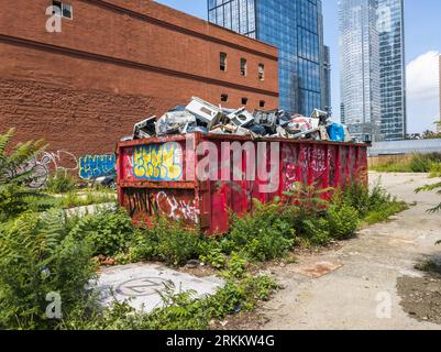 Dumpster filled with discarded air conditioners and other mechanical equipment in Hell’s Kitchen in New York on Wednesday, August 16, 2023. (© Richard B. Levine) Stock Photo