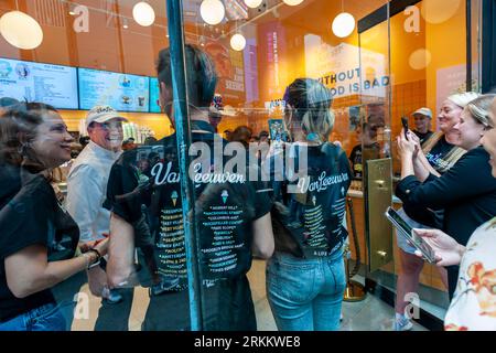 Hunderte von Eisliebhabern warten am Donnerstag, den 24. August 2023, auf die Eröffnung des 50. Van Leeuwen Eisdielen-Ladens am Times Square in New York. Die Marke hat sich mit dem berühmten Küchenchef Jean-Georges Vongerichten zusammengetan, um eine Sonderedition mit dem Geschmack „Sour Cherry Creamsicle“ zu kreieren. (© Richard B. Levine) Stockfoto