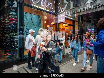 Hunderte von Eisliebhabern warten am Donnerstag, den 24. August 2023, auf die Eröffnung des 50. Van Leeuwen Eisdielen-Ladens am Times Square in New York. Die Marke hat sich mit dem berühmten Küchenchef Jean-Georges Vongerichten zusammengetan, um eine Sonderedition mit dem Geschmack „Sour Cherry Creamsicle“ zu kreieren. (© Richard B. Levine) Stockfoto