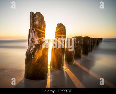 Wellenbrecher am Meer - Sonnenuntergang am Meer - Sonnenstrahlen, Wellenbrecher und Meer - Dziwnów - Polen Stockfoto