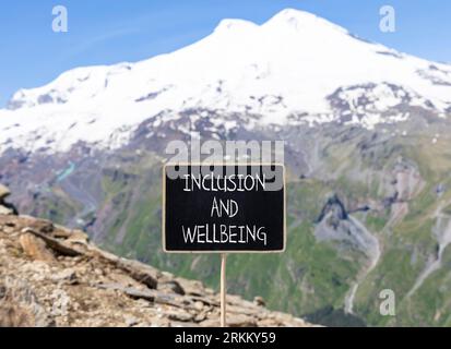 Symbol für Inklusion und Wohlbefinden. Konzeptbegriffe Inklusion und Wohlbefinden auf wunderschöner Kreidetafel. Schöner Elbusberg im Hintergrund. Motivationa Stockfoto