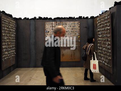 (111118) -- BEIJING, Nov. 18, 2011 (Xinhua) -- Visitors view an exhibit made with porcelain pieces at Translating China -- Solo Exhibition of Jannis Kounellis in Beijing, capital of China, Nov. 18, 2011. The installation exhibition Translating China -- Solo Exhibition of Jannis Kounellis kicked off in Beijing on Friday. This exhibition witnesses the whole new works by Jannis Kounellis, the famous Arte Povera master from Italy. Artists of Arte Povera often use junks and everyday materials as the media of their artworks. (Xinhua/Jin Liangkuai) (zgp) CHINA-BEIJING-JANNIS KOUNELLIS-EXHIBITION (CN) Stock Photo