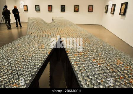 (111118) -- BEIJING, Nov. 18, 2011 (Xinhua) -- Photo taken on Nov. 18, 2011 shows an installation composed of thousands of glass cups filled with erguotou, a Chinese grain alcohol, at Translating China -- Solo Exhibition of Jannis Kounellis in Beijing, capital of China. The installation exhibition Translating China -- Solo Exhibition of Jannis Kounellis kicked off in Beijing on Friday. This exhibition witnesses the whole new works by Jannis Kounellis, the famous Arte Povera master from Italy. Artists of Arte Povera often use junks and everyday materials as the media of their artworks. (Xinhua/ Stock Photo