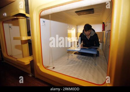 Bildnummer: 56305263 Datum: 18.11.2011 Copyright: imago/Xinhua (111118) -- JINAN, 18. November 2011 (Xinhua) -- Ein Erlebnisexperte liest ein Buch in einer Hütte in einem Capsule inn in Jinan, ostchinesische Provinz Shandong, 18. November 2011. In Jinan wurde ein Capsule inn im japanischen Stil mit einem 1,2 Meter hohen, 1,0 Meter breiten und 2,0 Meter langen Zimmer in Schrankgröße eröffnet. Alle Kapseln sind mit Steckdosen, Leuchten und Flachbildfernsehern ausgestattet. (Xinhua/Gong Hui) (ljh) CHINA-SHANDONG-JINAN-CAPSULE INN (CN) PUBLICATIONxNOTxINxCHN Wirtschaft Tourismus Hotel Kabine Zimmer Hotelzimmer Kammer Mini Schl Stockfoto