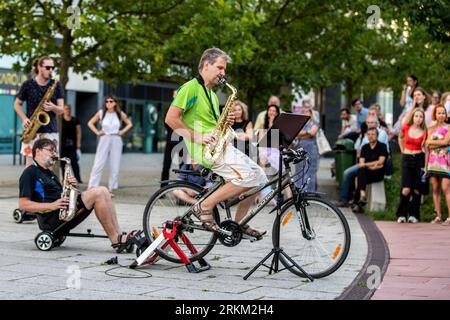 Ostrava, Tschechische Republik. 25. August 2023. Die Oper im Rhythmus von Techno-Optimismus für 2 E-Scooter und 4 Hoverboards Bachelor Party von Frantisek Chaloupka wurde während der 12. Ostrava Days Biennale of Contemporary Music vor dem Haupteingang des Forum Nova Karolina, 25. August 2023, Ostrava, aufgeführt. Quelle: Vladimir Prycek/CTK Photo/Alamy Live News Stockfoto