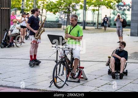 Ostrava, Tschechische Republik. 25. August 2023. Die Oper im Rhythmus von Techno-Optimismus für 2 E-Scooter und 4 Hoverboards Bachelor Party von Frantisek Chaloupka wurde während der 12. Ostrava Days Biennale of Contemporary Music vor dem Haupteingang des Forum Nova Karolina, 25. August 2023, Ostrava, aufgeführt. Quelle: Vladimir Prycek/CTK Photo/Alamy Live News Stockfoto