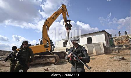 Bildnummer: 56429755  Datum: 24.11.2011  Copyright: imago/Xinhua (111124) -- BIET HANENA, Nov. 24, 2011 (Xinhua) -- Israeli Soldiers stand guard as a bulldozer destroys Palestinian houses in the West Bank village of Biet Hanena near the city of Ramallah, on Nov. 24, 2011. Israeli troops demolished four houses of Bedouin residents in the West Bank under the pretext of not having building permits on Thursday.(Xinhua/Fadi Arouri)(wn) MIDEAST-WEST BANK-DEMOLISHMENT PUBLICATIONxNOTxINxCHN Politik Gesellschaft Westjordanland Nahostkonflikt Zerstörung Wohnhaus xjh x0x premiumd 2011 quer      56429755 Stock Photo